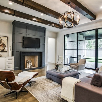 Transitional medium tone wood floor and brown floor living room photo in Dallas with white walls, a standard fireplace and a wall-mounted tv