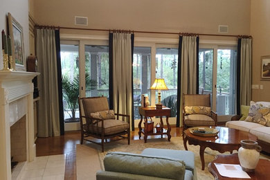 На фото: большая открытая гостиная комната в стиле неоклассика (современная классика) с серыми стенами, паркетным полом среднего тона, стандартным камином, фасадом камина из камня и телевизором на стене