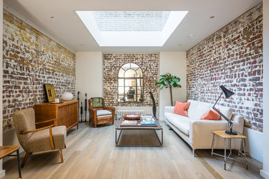 Urban formal light wood floor living room photo in London with multicolored walls and no tv