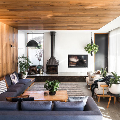Living room - large contemporary open concept concrete floor and gray floor living room idea in Hobart with white walls, a wood stove, a concrete fireplace and a concealed tv
