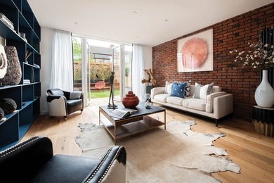 Modernes Wohnzimmer ohne Kamin mit hellem Holzboden und Ziegelwänden in London