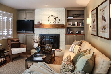 Offenes Klassisches Wohnzimmer mit beiger Wandfarbe, braunem Holzboden, Kamin, Kaminumrandung aus Backstein und Multimediawand in Denver