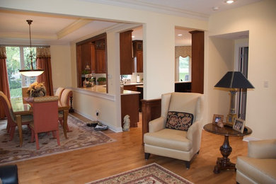 Immagine di un grande soggiorno tradizionale aperto con pareti gialle e pavimento in legno massello medio