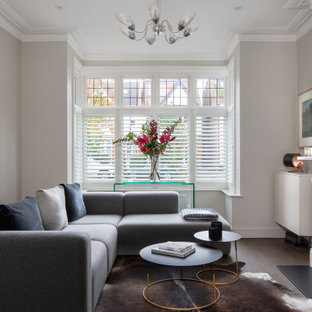 This is an example of a medium sized classic living room in London with grey walls, a wood burning stove and brown floors.
