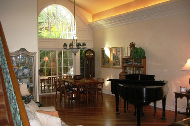 Cette photo montre un grand salon chic ouvert avec une salle de réception, un mur blanc et un sol en bois brun.
