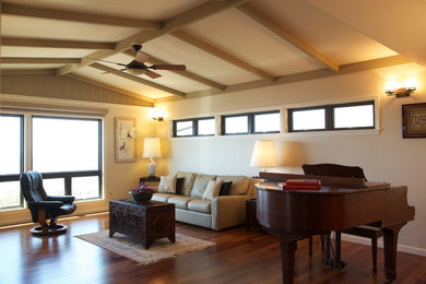 Ejemplo de salón con rincón musical cerrado exótico de tamaño medio con paredes beige y suelo de madera oscura