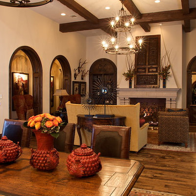 Living room - mediterranean open concept medium tone wood floor living room idea in Dallas with beige walls, a standard fireplace and a stone fireplace