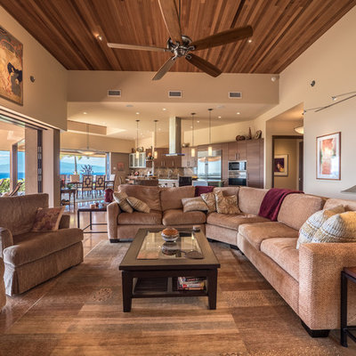 Large island style open concept limestone floor and beige floor living room photo in Hawaii with beige walls and a tv stand