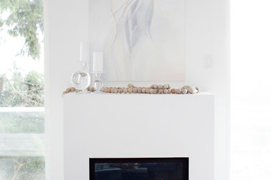 バンクーバーにある高級な小さなトランジショナルスタイルのおしゃれなLDK (白い壁、濃色無垢フローリング、標準型暖炉、漆喰の暖炉まわり) の写真