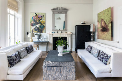 ロンドンにある高級な中くらいなトランジショナルスタイルのおしゃれなリビング (白い壁、淡色無垢フローリング、標準型暖炉、石材の暖炉まわり、ベージュの床) の写真