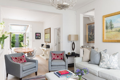 Inspiration for a mid-sized eclectic open concept light wood floor living room remodel in London with yellow walls and a tv stand