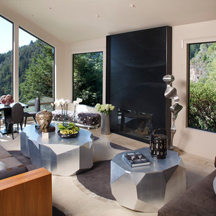 This is an example of a large world-inspired living room in San Francisco with beige walls and a metal fireplace surround.