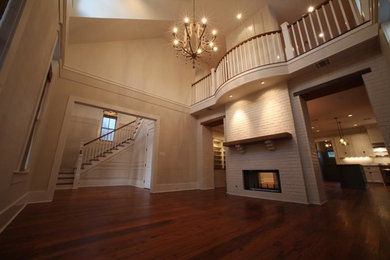 Inspiration for a medium sized formal enclosed living room in New Orleans with beige walls, medium hardwood flooring, a standard fireplace, no tv and brown floors.