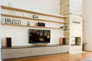 Exempel på ett stort modernt allrum med öppen planlösning, med vita väggar, mellanmörkt trägolv, en standard öppen spis, en spiselkrans i sten och en inbyggd mediavägg