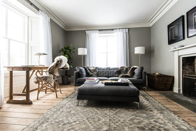 Mittelgroßes, Abgetrenntes Modernes Wohnzimmer mit grauer Wandfarbe, braunem Holzboden, Kamin und Kaminumrandung aus Holz in Edinburgh