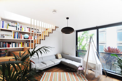 Aménagement d'un petit salon contemporain ouvert avec un sol en bois brun, un mur blanc et aucune cheminée.