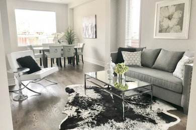 Offenes Modernes Wohnzimmer mit weißer Wandfarbe und braunem Boden in Toronto