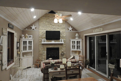 На фото: открытая гостиная комната среднего размера в стиле кантри с бежевыми стенами, светлым паркетным полом, стандартным камином, фасадом камина из камня и телевизором на стене