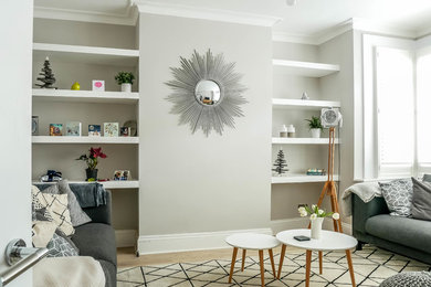 Medium sized enclosed living room in London with no fireplace, beige floors, grey walls and medium hardwood flooring.