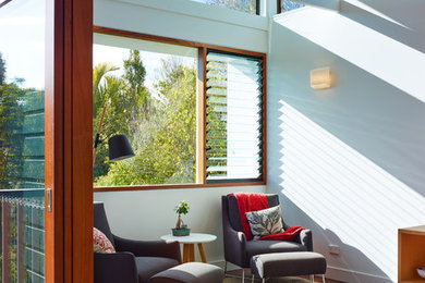Modernes Wohnzimmer mit weißer Wandfarbe und braunem Holzboden in Brisbane