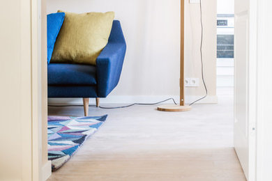 Imagen de salón abierto nórdico pequeño con paredes beige y suelo de madera clara