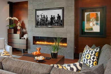 Ejemplo de salón abierto de estilo zen con paredes beige, suelo de madera en tonos medios, chimenea lineal, marco de chimenea de piedra y televisor colgado en la pared