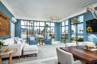 Example of a beach style open concept gray floor living room design in San Diego with blue walls and a wall-mounted tv