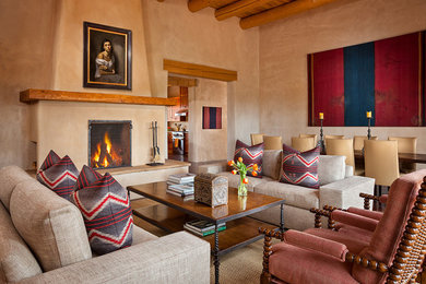 Southwest formal and open concept dark wood floor living room photo in Albuquerque with beige walls, a standard fireplace, a stone fireplace and no tv