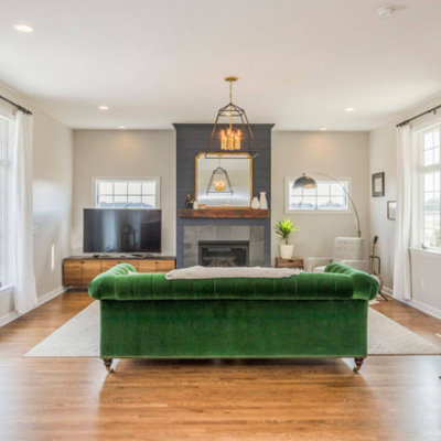 Inspiration for a mid-sized transitional formal and open concept medium tone wood floor and brown floor living room remodel in Cedar Rapids with white walls, a standard fireplace, a tile fireplace and a tv stand