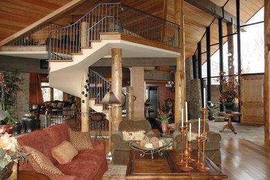 Foto de salón para visitas abierto rústico grande sin chimenea y televisor con paredes marrones, suelo de madera clara y suelo marrón