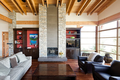Trendy dark wood floor living room photo in Calgary with beige walls, a standard fireplace, a stone fireplace and a media wall