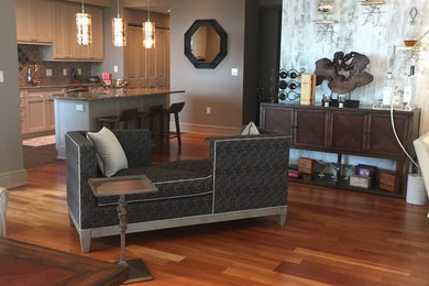 Example of a mid-sized transitional open concept medium tone wood floor living room design in Milwaukee with a bar, gray walls and a tv stand
