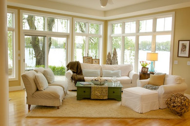 Modelo de salón abierto costero de tamaño medio sin televisor con suelo de madera en tonos medios, paredes beige y suelo beige
