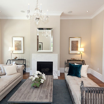 Example of a classic living room design in San Francisco with beige walls and a standard fireplace