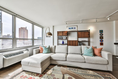 Immagine di un soggiorno minimalista di medie dimensioni e aperto con pareti bianche, parquet scuro e pavimento marrone
