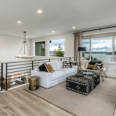 Living room - mid-sized contemporary loft-style medium tone wood floor and beige floor living room idea in Seattle with white walls and a wall-mounted tv