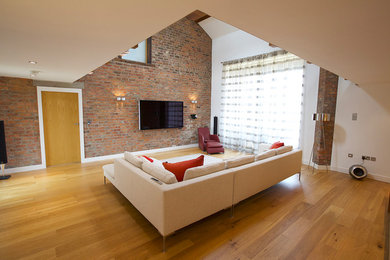 Large contemporary mezzanine living room in Other with a music area, light hardwood flooring and a wall mounted tv.