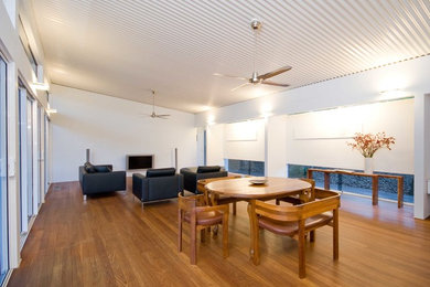 Großes, Offenes Modernes Wohnzimmer mit weißer Wandfarbe, braunem Holzboden und TV-Wand in Brisbane