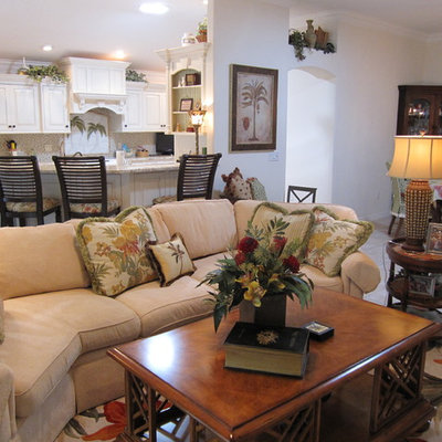 Inspiration for a tropical open concept living room remodel in Orlando with white walls, no fireplace and a media wall