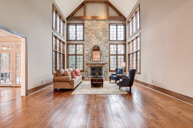 Example of a mid-sized classic formal and enclosed dark wood floor and brown floor living room design in Philadelphia with beige walls, a standard fireplace and a stone fireplace
