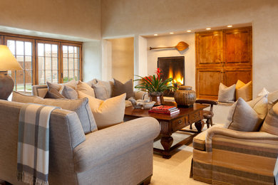 Living room - southwestern formal and open concept dark wood floor living room idea in Albuquerque with beige walls, a standard fireplace, a stone fireplace and no tv
