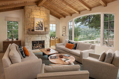 Large mountain style open concept light wood floor living room photo in Santa Barbara with white walls, a standard fireplace, a stone fireplace and no tv