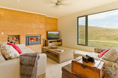 Exempel på ett modernt allrum med öppen planlösning, med travertin golv, en standard öppen spis, en spiselkrans i trä och en fristående TV