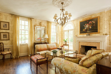 Foto de salón para visitas cerrado clásico grande con paredes amarillas, suelo de madera en tonos medios y todas las chimeneas