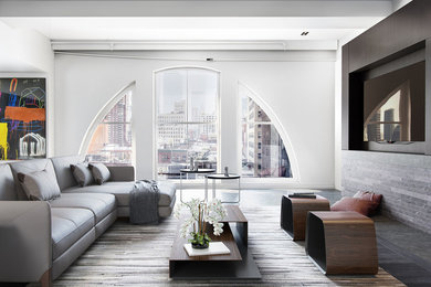 Living room - mid-sized contemporary loft-style dark wood floor living room idea in New York with gray walls and a media wall