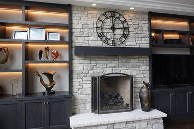 Example of a mid-sized trendy enclosed dark wood floor and black floor living room design in Chicago with beige walls, a standard fireplace, a stone fireplace and no tv