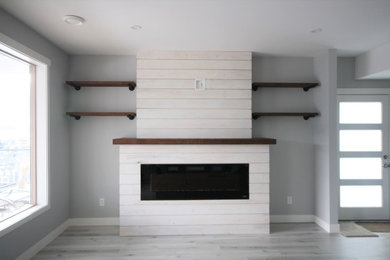 Imagen de salón actual de tamaño medio con paredes grises, chimenea lineal y marco de chimenea de madera