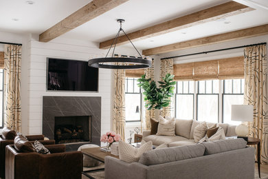Inspiration for a farmhouse light wood floor and beige floor living room remodel in Detroit with white walls, a standard fireplace, a stone fireplace and a wall-mounted tv