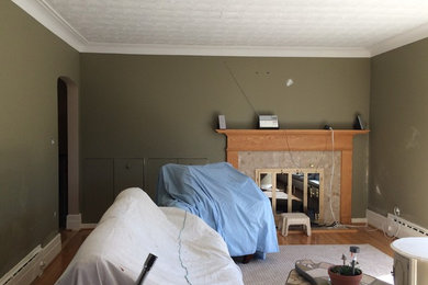 На фото: изолированная гостиная комната среднего размера в классическом стиле с зелеными стенами, светлым паркетным полом, стандартным камином, фасадом камина из дерева и коричневым полом с