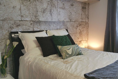 Imagen de dormitorio moderno pequeño con paredes grises, suelo de madera clara y chimeneas suspendidas